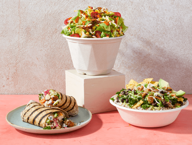 Two salads and a warm bowl next to a paper Chopt bag